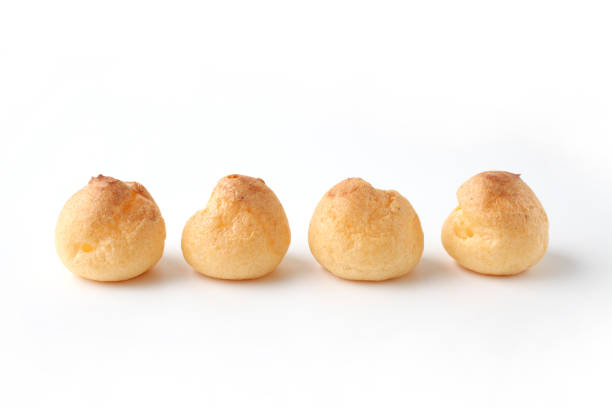 cream puffs aligned closeup isolated on white background cream puffs closeup isolated on white backgroundcream puffs aligned closeup isolated on white background choux pastry photos stock pictures, royalty-free photos & images