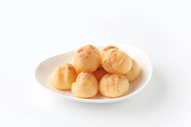 istock cream puffs on plate closeup isolated on white background 1206979853