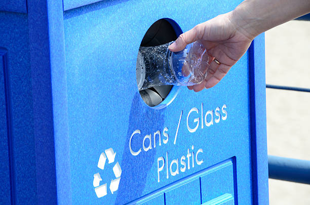Hand depositing plastic in the recycling bin