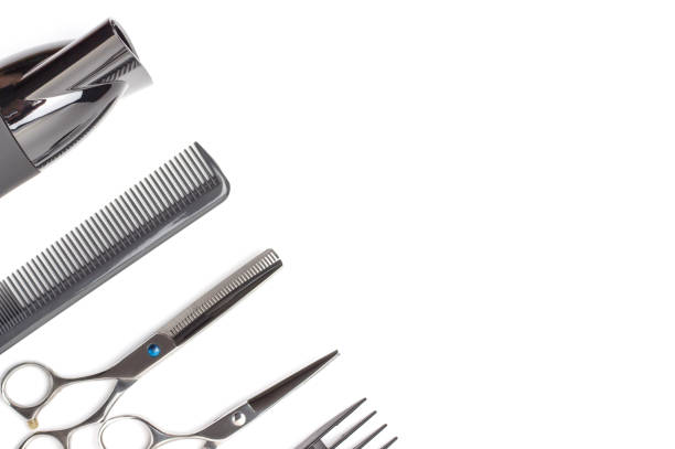 Hairdressing tools and hairdryer on a white background, top view, copy space.