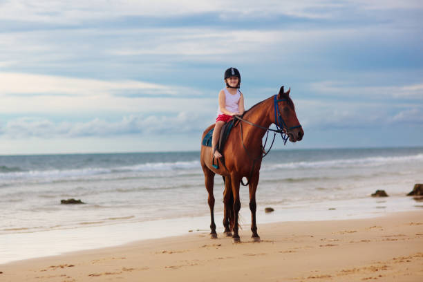 bambini a cavallo sulla spiaggia. i bambini cavalcano i cavalli. - 4611 foto e immagini stock