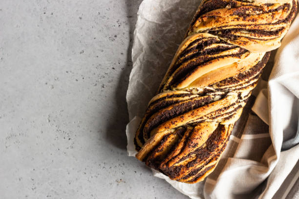 brioche vorticoso con semi di papavero. semi di papavero intrecciati o pane in rotolo, babka. pane tradizionale polacco dolce natalizio. - polish bread foto e immagini stock