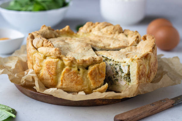 istock Spinach, chicken and ricotta pie with fresh spinach leaves, ricotta and eggs on a light stone background. 1206985564