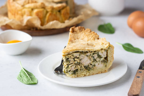 istock Spinach, chicken and ricotta pie with fresh spinach leaves, ricotta and eggs on a light stone background. 1206985640