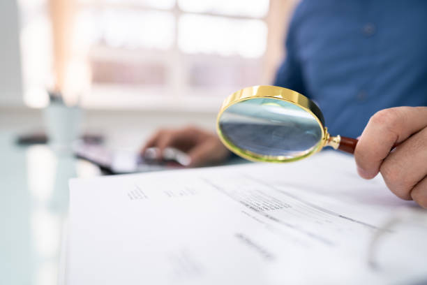 istock Businessperson Checking Invoice With Magnifying Glass 1206990194