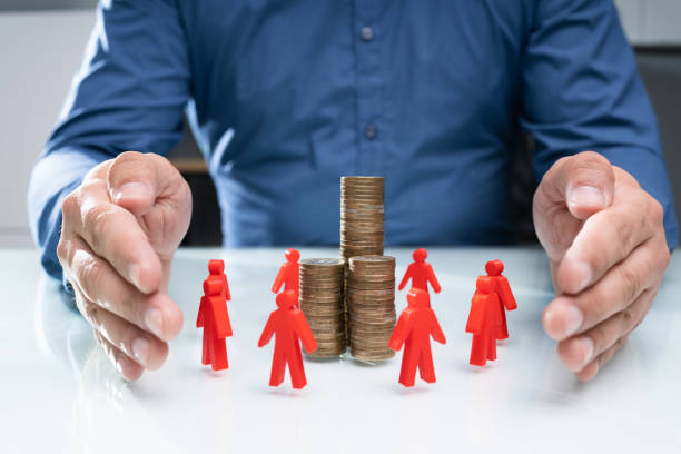 istock Protecting Red Human Figures Surrounding Stacked Coins 1206990327