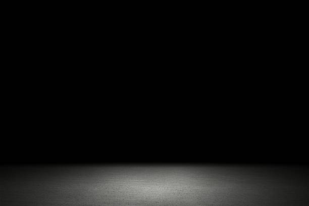 istock Light shining down on white cement floor in dark room with copy space, abstract background 1206991596