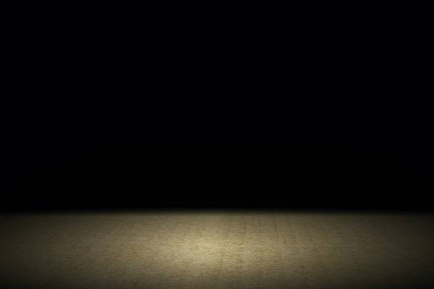 istock Light shining down on brown carpet floor in dark room with copy space, abstract background 1206991602