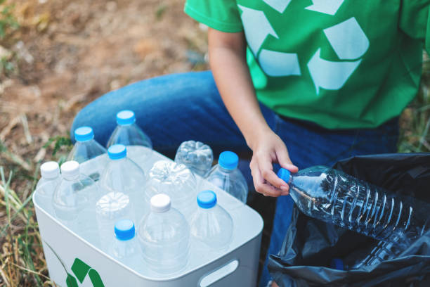 istock A woman picking up garbage plastic bottles into a box and plastic bag 1206992452