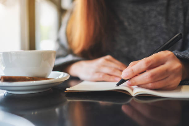 istock a woman writing on a blank notebook on the table 1206995037