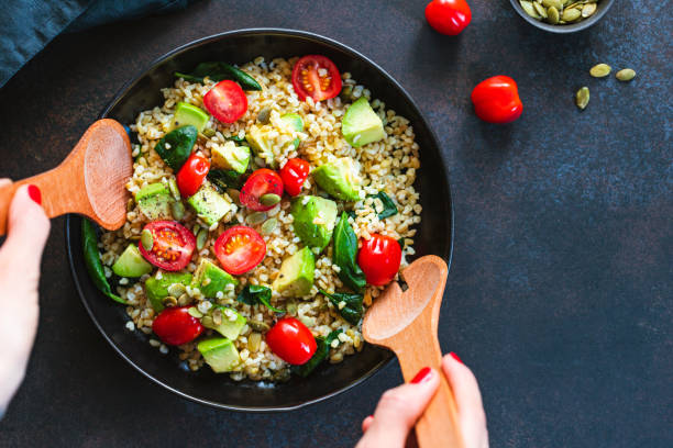 istock Healthy salad with bulgur, avocado, spinach and cherry tomatoes. Top view. 1206996329