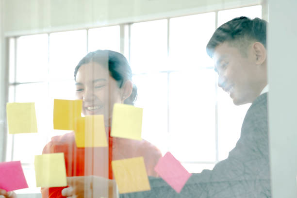 istock Young creative people making plans on a glass wall at casual office. 1206998290