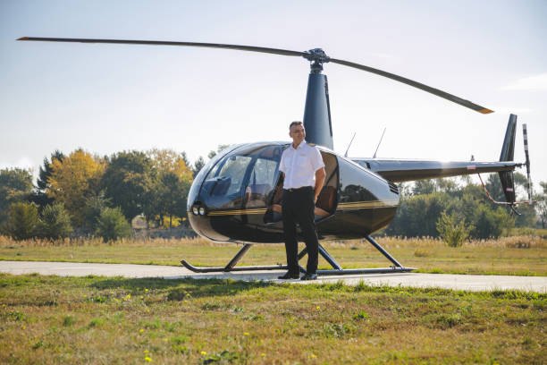 istock Smiling pilot standing by grounded helicopter on airfield 1206998752
