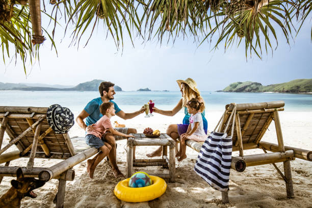 istock Happy family talking while relaxing on deck chairs at the beach. 1206999398