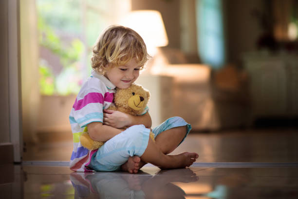 istock Child playing with teddy bear. Kid and toy at home 1206999601