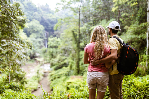 istock Back view of embraced couple looking at view in rainforest. 1207000607