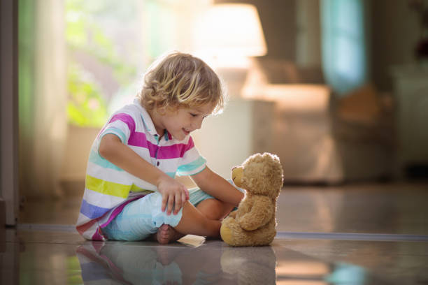 istock Child playing with teddy bear. Kid and toy at home 1207000726