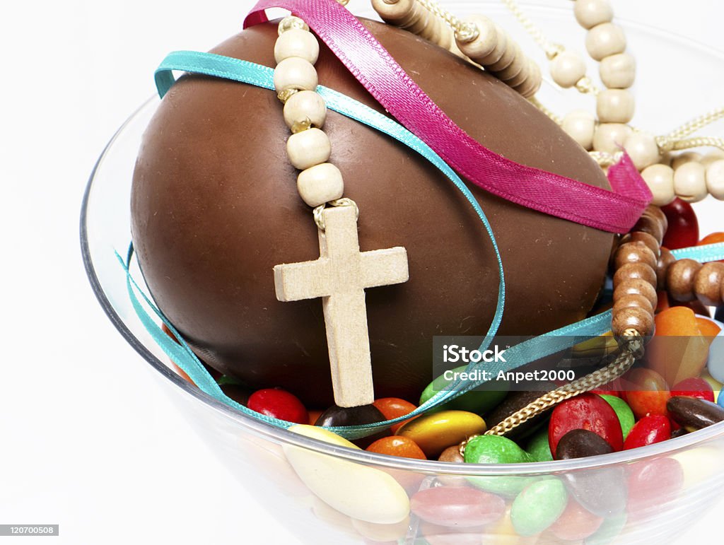 easter chocolate egg , sweets and cross in a glass easter chocolate egg , sweets and cross in a glass on a light background Bowl Stock Photo