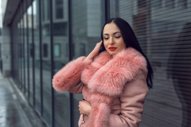 istock Brunette in the city in a pink coat 1207005692