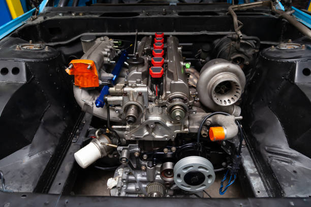 istock Powerful tuned gasoline engine with a turbocharger and a charger in the engine compartment of an automobile with an open hood and a turbine in a car repair and improvement workshop. 1207007295