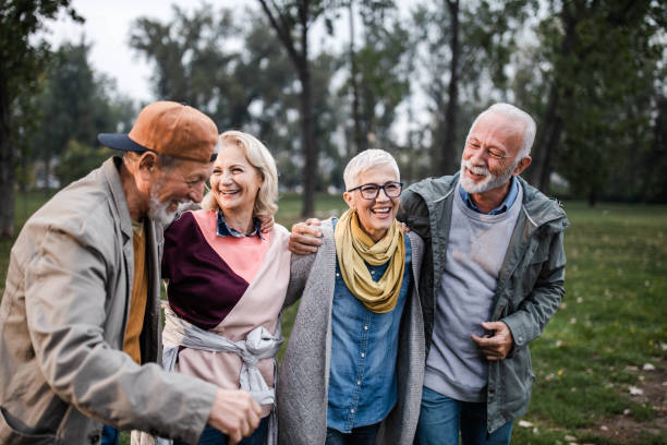 istock Happy seniors talking while walking embraced in nature. 1207008366