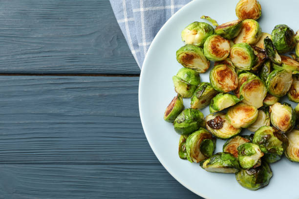 istock Plate with brussels sprout on wooden background, top view 1207008534