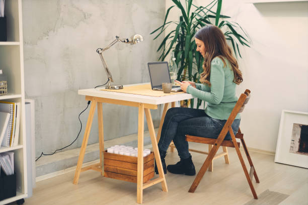 istock Young attractive female sitting in the modern office and typing. 1207009697