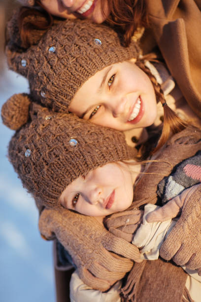 istock Two sisters embrace in winter clothes 1207011342