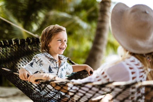 istock Cheerful boy relaxing with his mother in a hammock at the beach. 1207011641