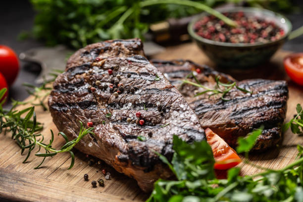 istock Juicy beef rib eye steak with herbs tomatoes salt and spices 1207020143