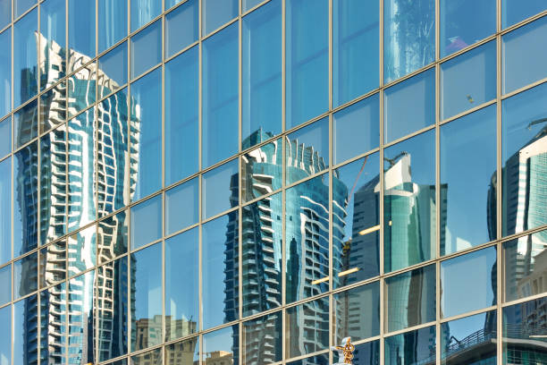 Reflection of skyscrapers in the glass wall of modern tower -  architectural background