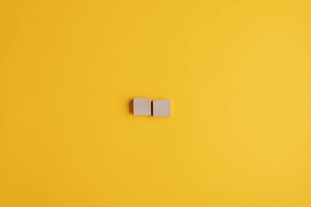 istock Two blank wooden blocks over yellow background 1207024663