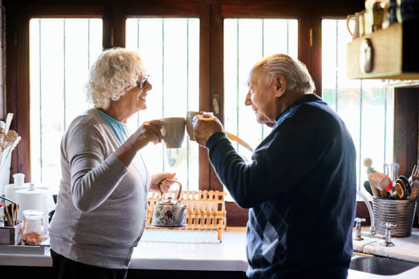 istock Elderly couple toasting coffee cups in kitchen 1207027481
