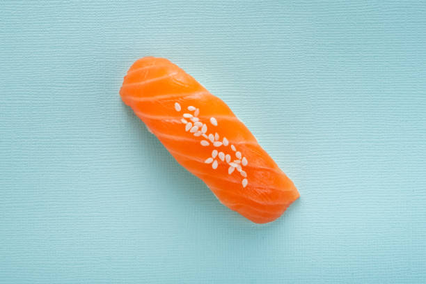 ein sushi nigiri mit lachs auf blauem hintergrund, ansicht von oben - sake nigiri stock-fotos und bilder