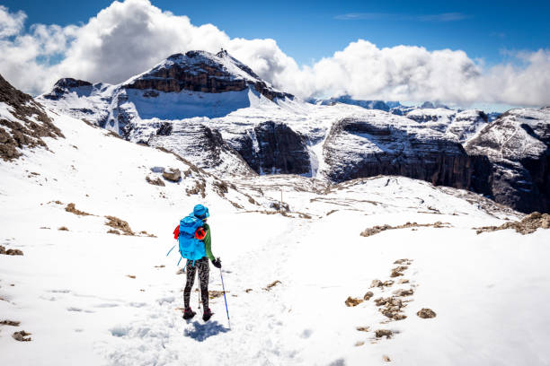 Woman backpacker tourist standing alone mountains snow, looking at scenic landscape view, South Tyrol Rifugio Boè, Alps, travel Italy alone Europe tourism.