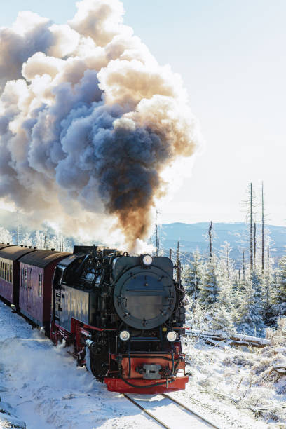 eine alte dampflokomotive in schneebedeckter landschaft - locomotive steam train train snow stock-fotos und bilder