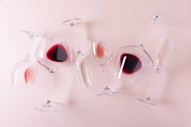 istock Assorted wineglasses with red, rose and white wine lying on pink background. Wine tasting concept. Flat lay. Top view. Copy space 1207033325