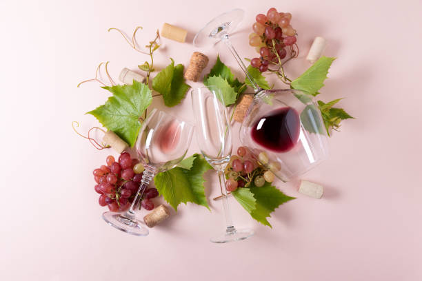 istock Assorted wineglasses with red, rose and white wine, grape, leaves and cork lying on pink background. Wine tasting concept. Flat lay. Top view. Copy space 1207033352