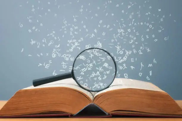 Individual letters fly magically out of pages of open book