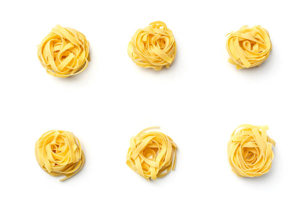 nido di fettuccine di pasta italiana isolato su sfondo bianco. visualizzazione dall'alto - pasta noodles tagliatelle freshness foto e immagini stock