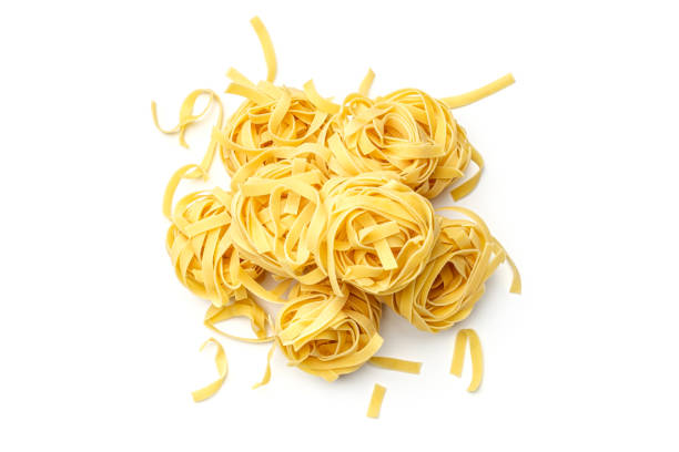 nido di fettuccine di pasta italiana isolato su sfondo bianco. visualizzazione dall'alto - pasta noodles tagliatelle freshness foto e immagini stock