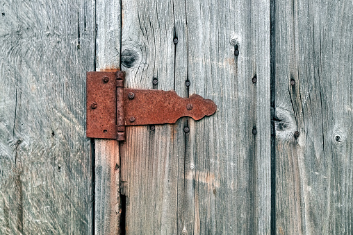 Old wooden not painted background, with rusty metal hinge