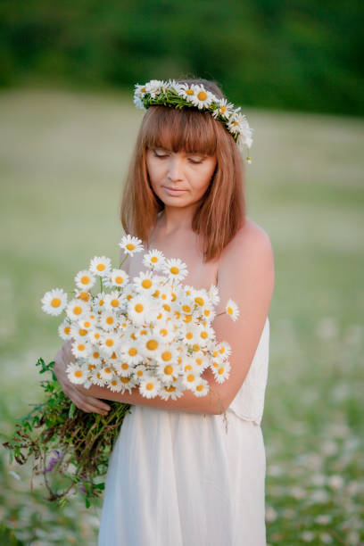istock A woman with a daisies wreath on her head. 1207035210