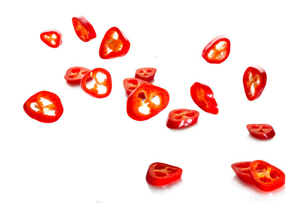 Chili pepper and its slices close-up falling Chili pepper and its slices close-up falling on a white background chilli powder stock pictures, royalty-free photos & images