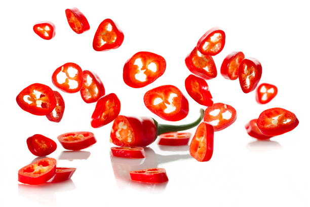 istock Chili pepper and its slices close-up falling 1207035373
