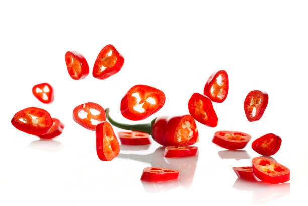 istock Chili pepper and its slices close-up falling 1207035382