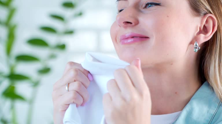 Woman smelling clean fresh linens and smiling