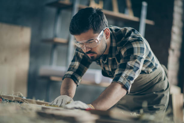 istock Portrait of his he nice attractive focused concentrated skilled experienced hardworking guy builder carving wood creating furniture at modern industrial loft brick style interior indoors 1207036819