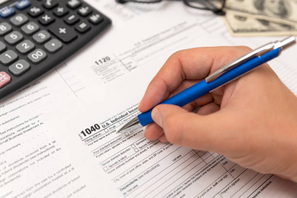 istock Man filling US tax form in office 1207038055