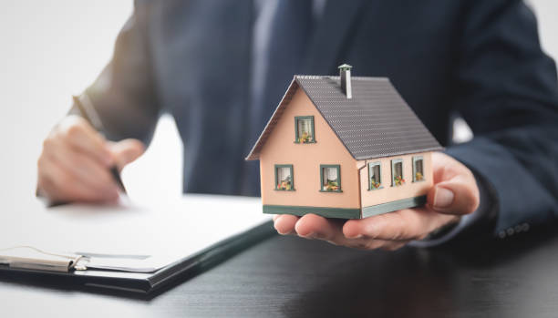 Real estate agent is holding a house model Real estate agent is holding a house model. Buy, loan for a house real estate office photos stock pictures, royalty-free photos & images
